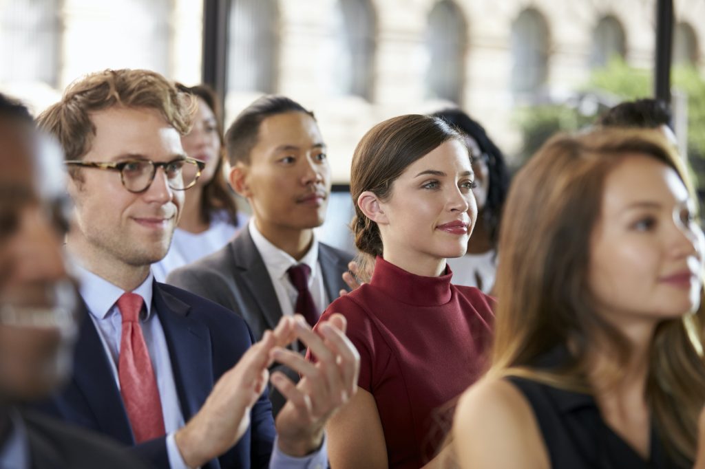 Audience applauding at a business seminar, close up